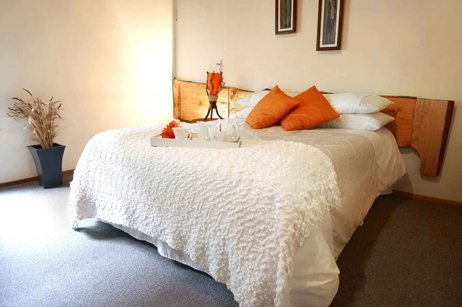 A double room with orange cushions and a tea tray